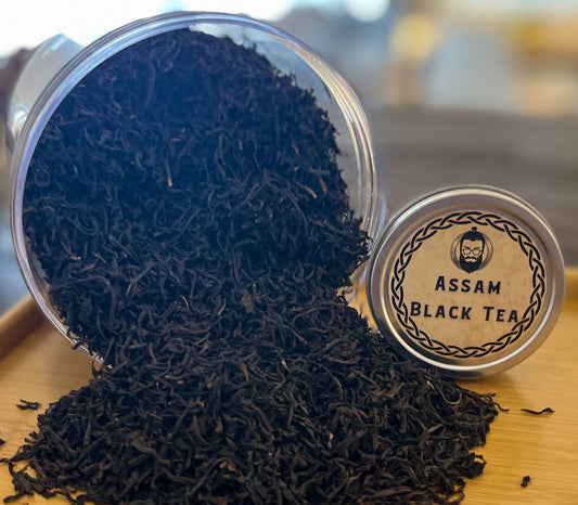 Assam Tea loose & flowing out of container with sample tin displaying name